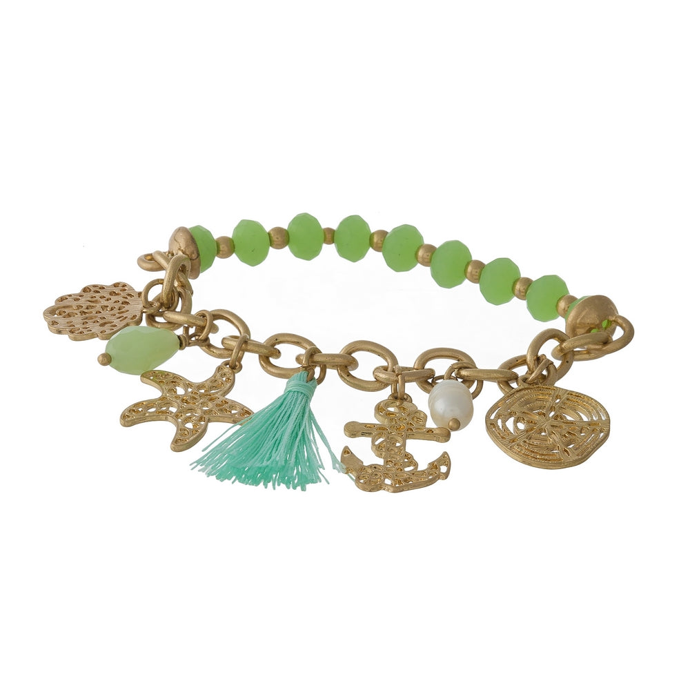 Gold tone and green beaded stretch bracelet displaying sealife and tassel charms