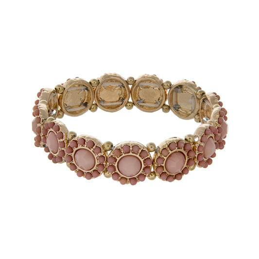 Gold tone stretch bracelet displaying disk with pink cabochons surrounded by pink beads