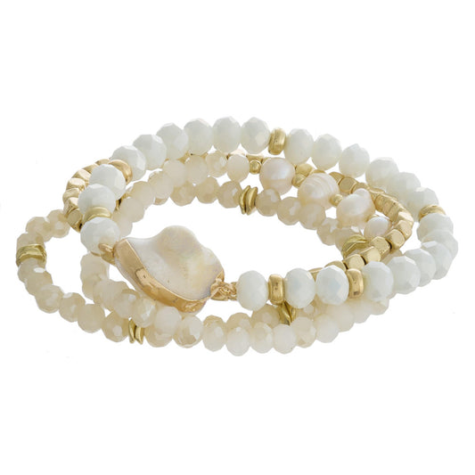 Bracelet set featuring four beaded stretch bracelets with faux pearls, faceted bead details and gold metal accents.